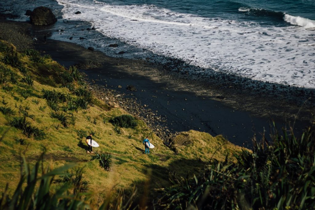 Praia de areia preta Maori Bay em Muriwai na Nova Zelândia.